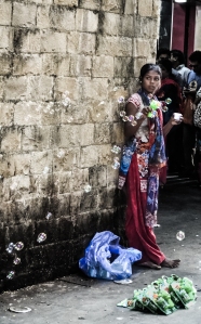 Millions in india are born is poverty and die due to poverty..there is very little exceptions from these people. may be that is the reason they are not given a fair chance to prove them self or come up in life...this image was taken near gate way of india, mumbai..this girl is trying to sell these bubble toys so tat she can get some money to feed her and her family....
